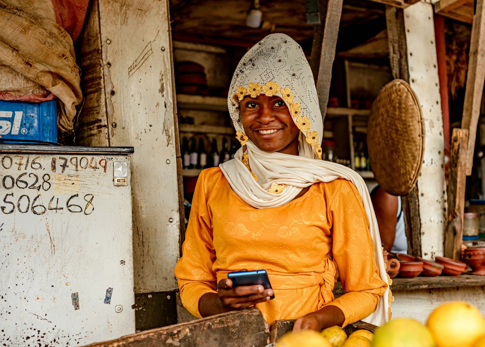 Vendeuse préparant une commande WhatsApp depuis son téléphone au Congo